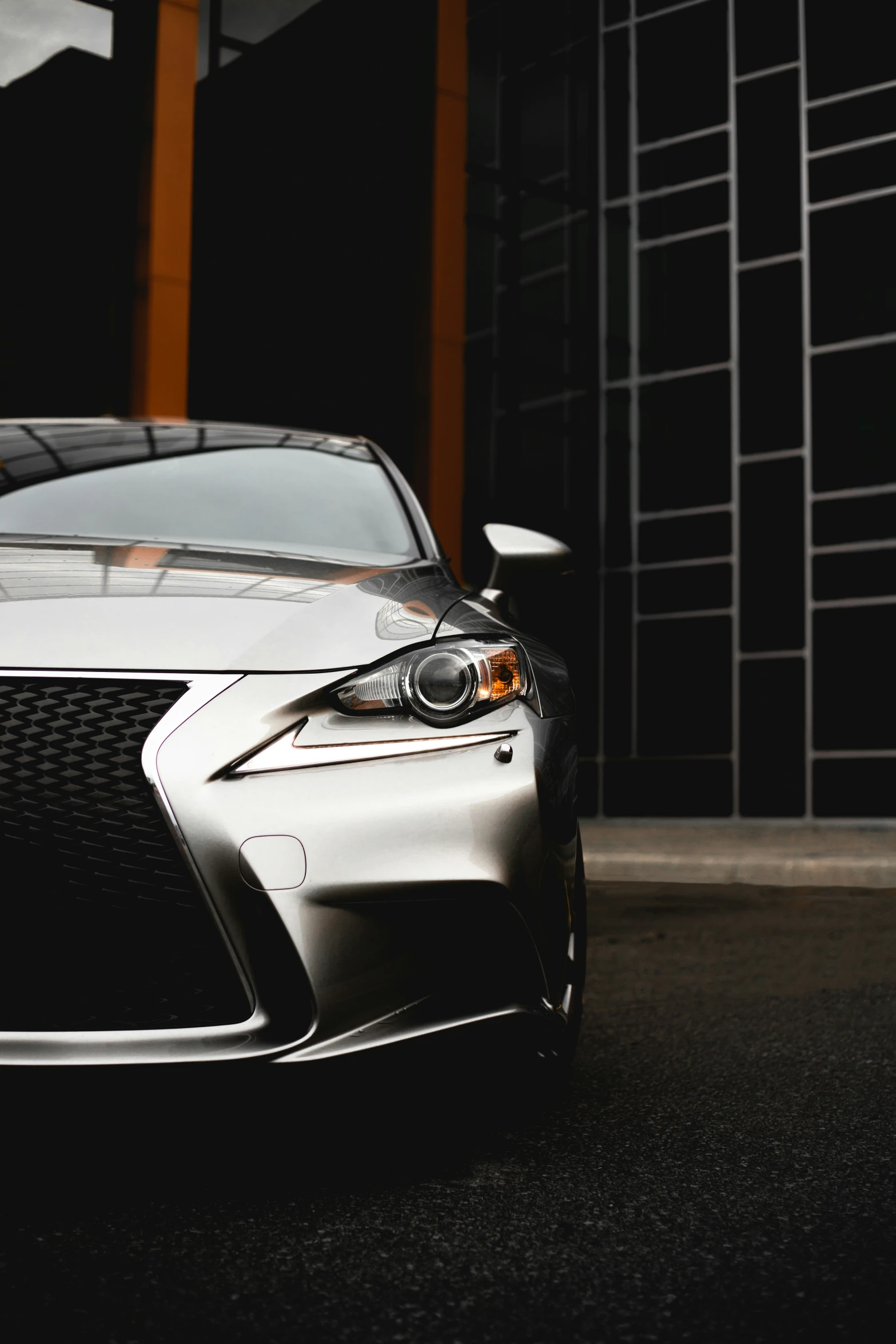 a silver car is shown parked by the wall