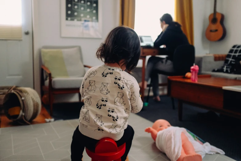 a baby playing with an open toy car next to a living room