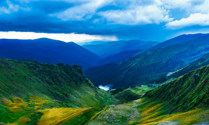 the green landscape is very beautiful under some dark clouds