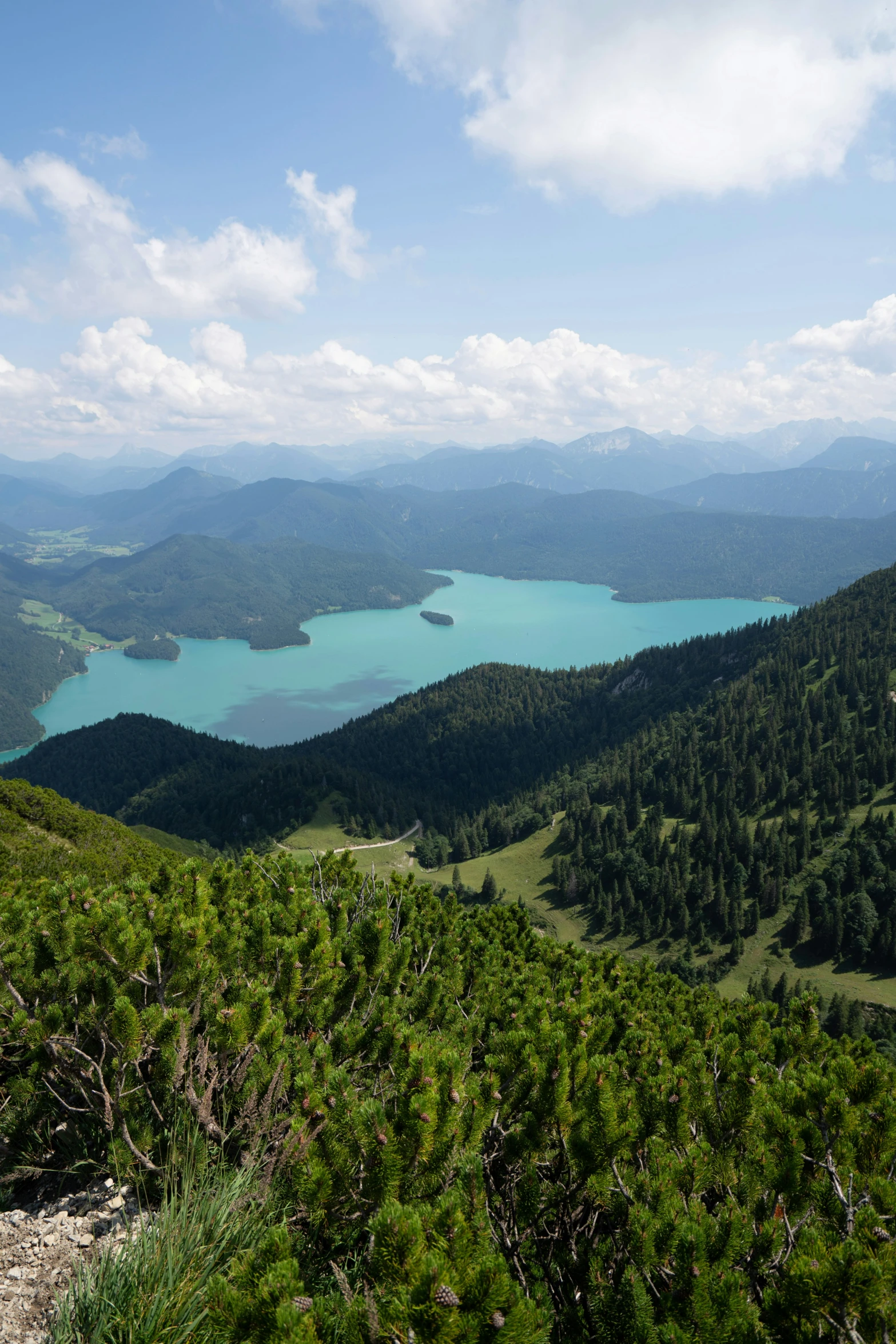 the top of the mountain with a view of blue lake and mountains