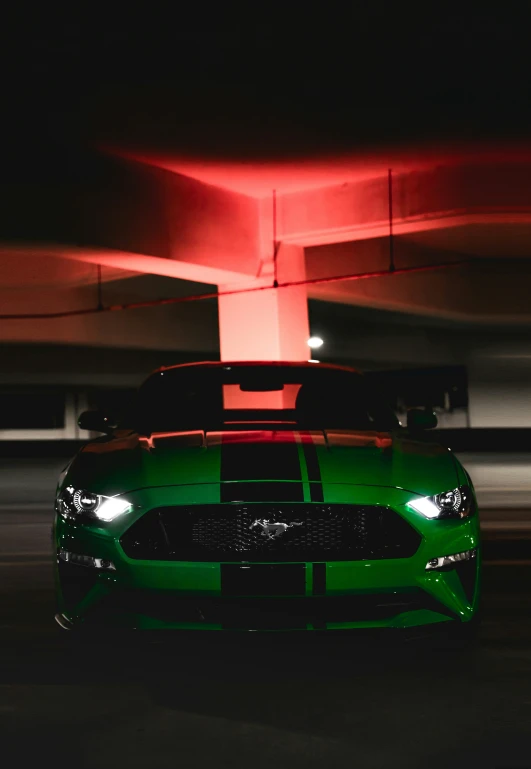 this green mustang sports car is parked under a parking garage