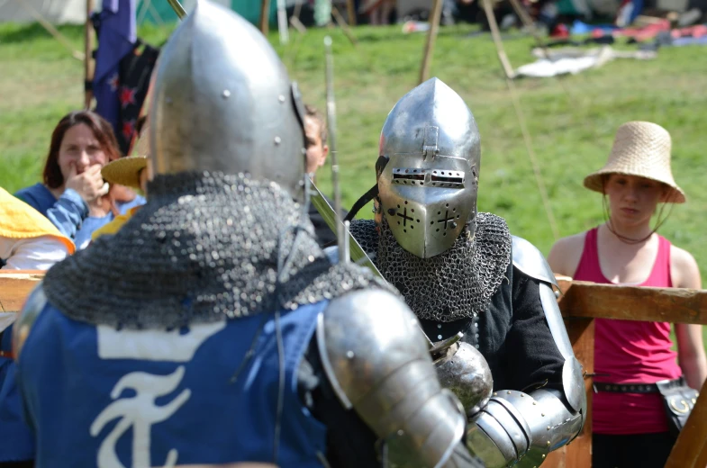 a man dressed in armor on a field with two other people