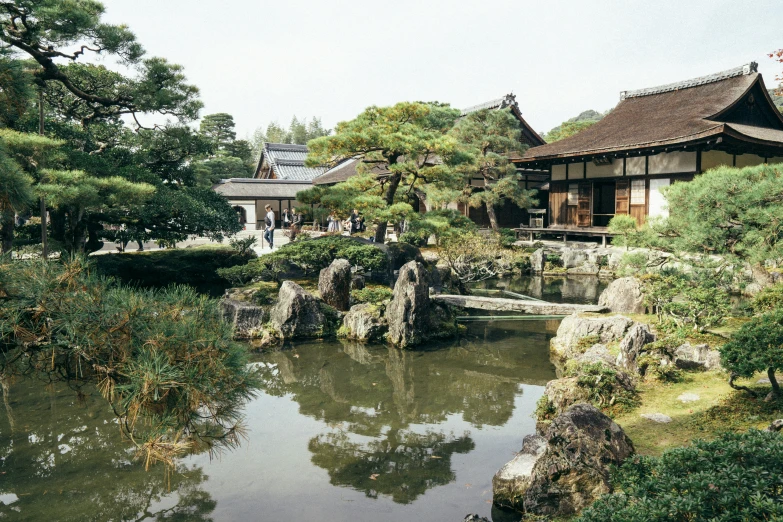 a river in the middle of a grassy area next to a building