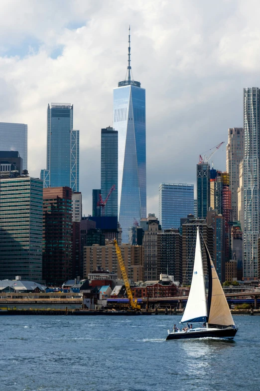 a sailboat with sail sails along a river