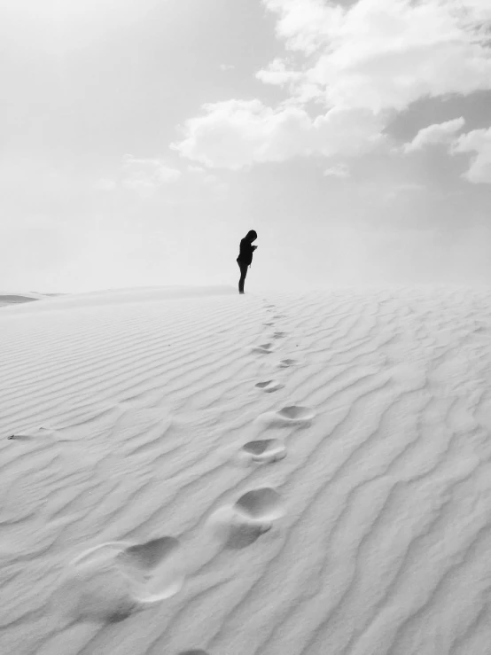 person walking in middle of beach with their feet in the sand