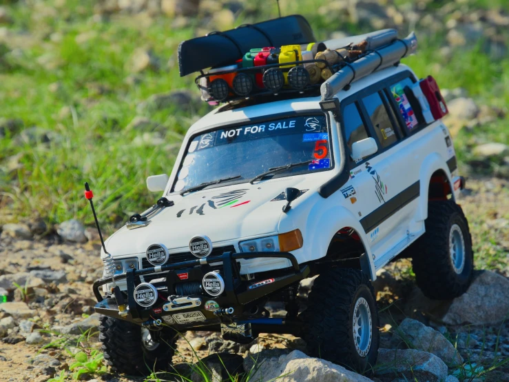 a white truck parked on the rocks in front of some rocks