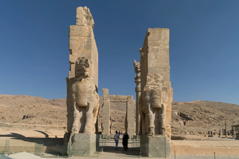 two ancient statues of lions and men facing each other