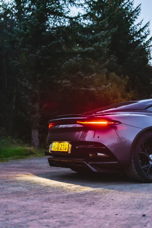 an exotic sports car driving on a road at night