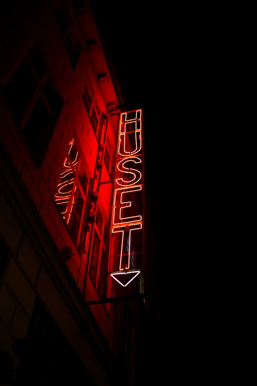 a neon sign is lit up in the dark