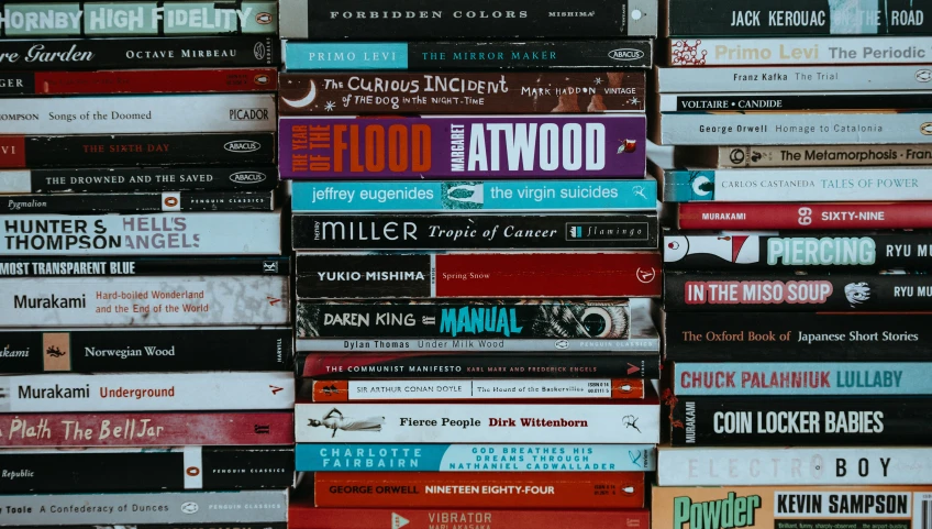 a wall covered in stacked books in multiple rows