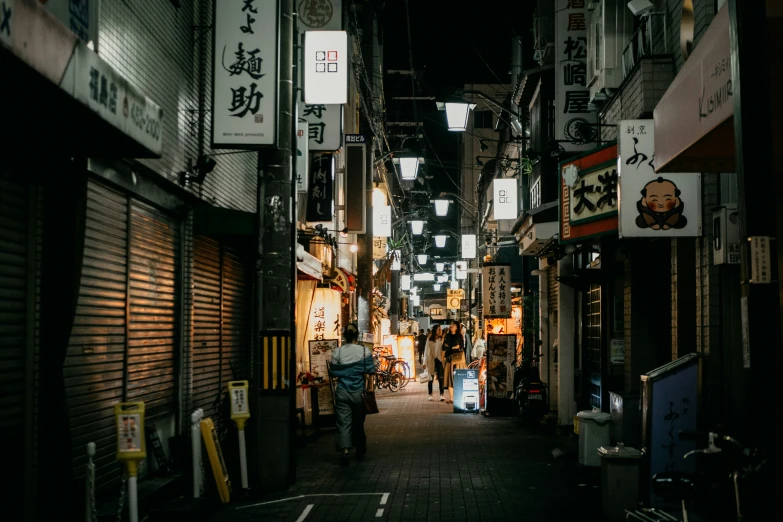 a dark alley with shop signs all around