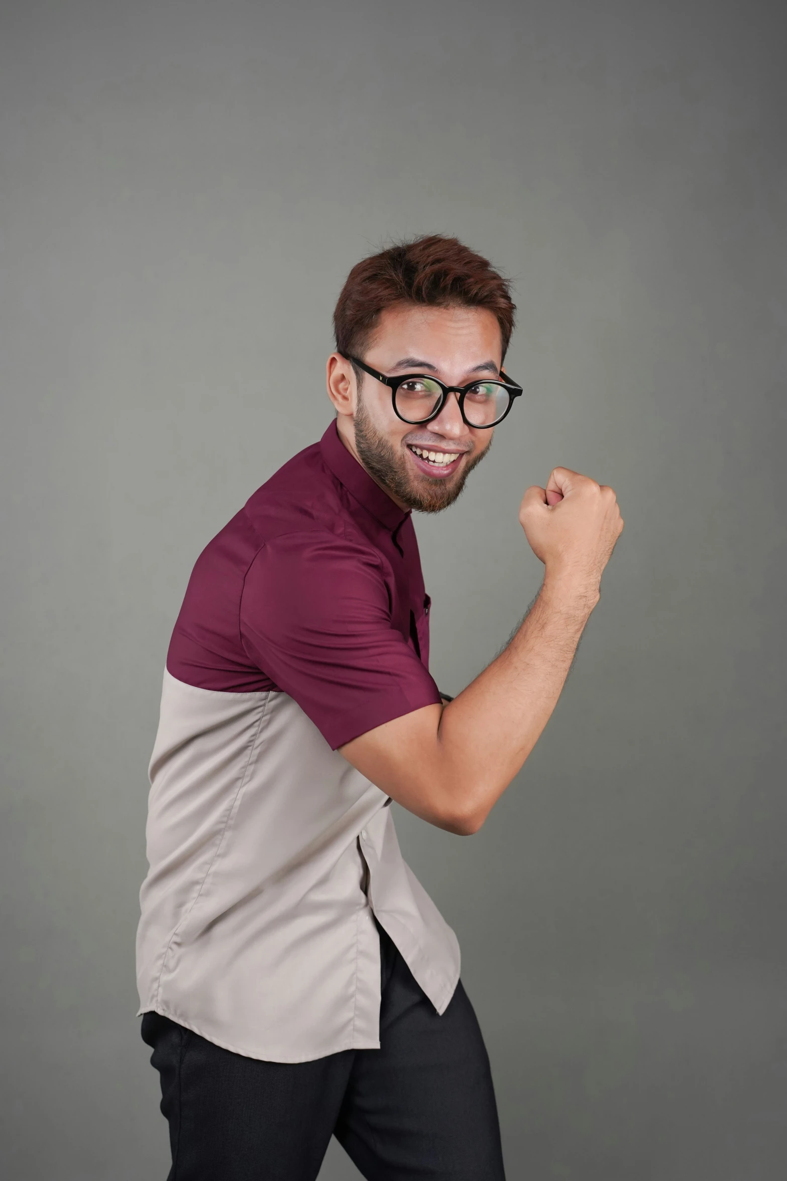 a young man in glasses, with his fist raised and his eyes closed