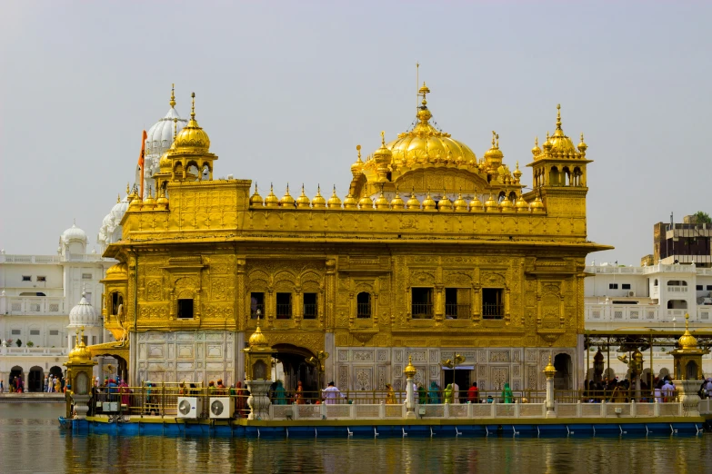 a large golden building with spires on top and the water around it