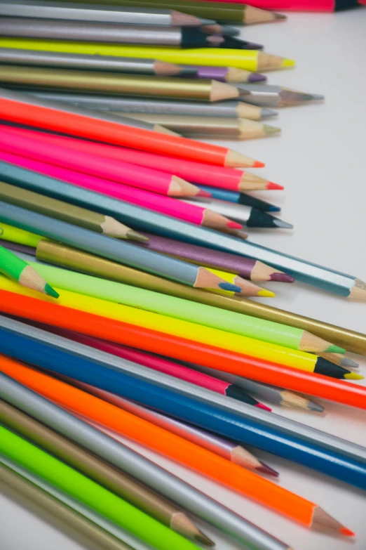 many colored pencils are lined up on a table