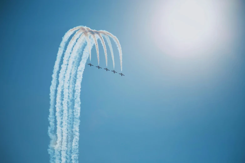 a group of planes flying in the air during the day