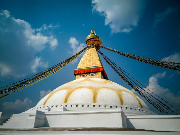 a view up at a bell tower with colorful ropes on it