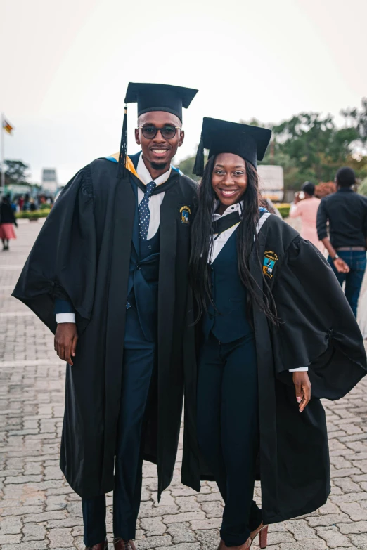 a man and woman posing for the camera in graduation robes