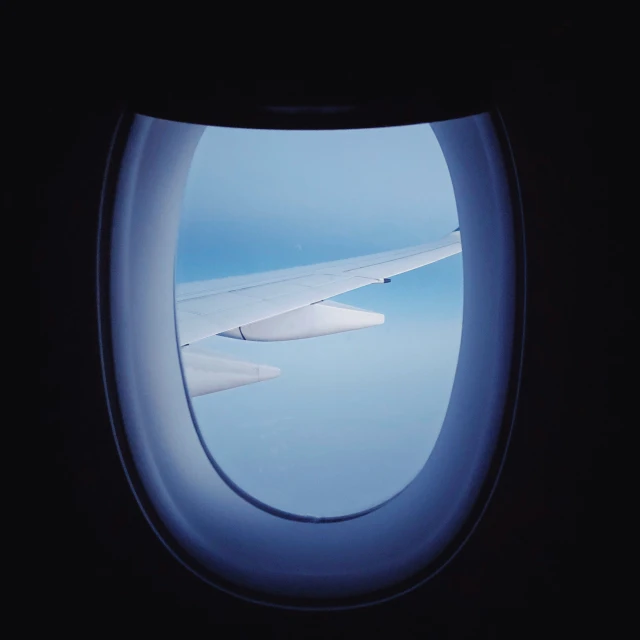 view from airplane window of the wing and sky