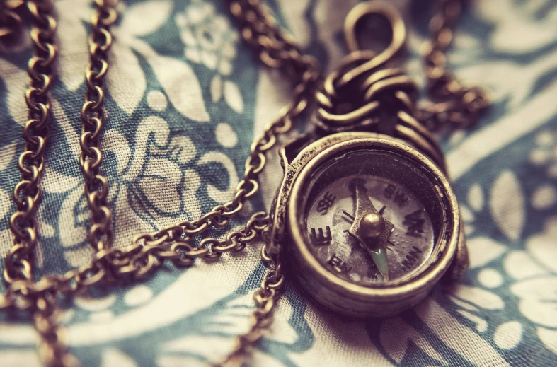 a vintage style pocket watch laying on a chain