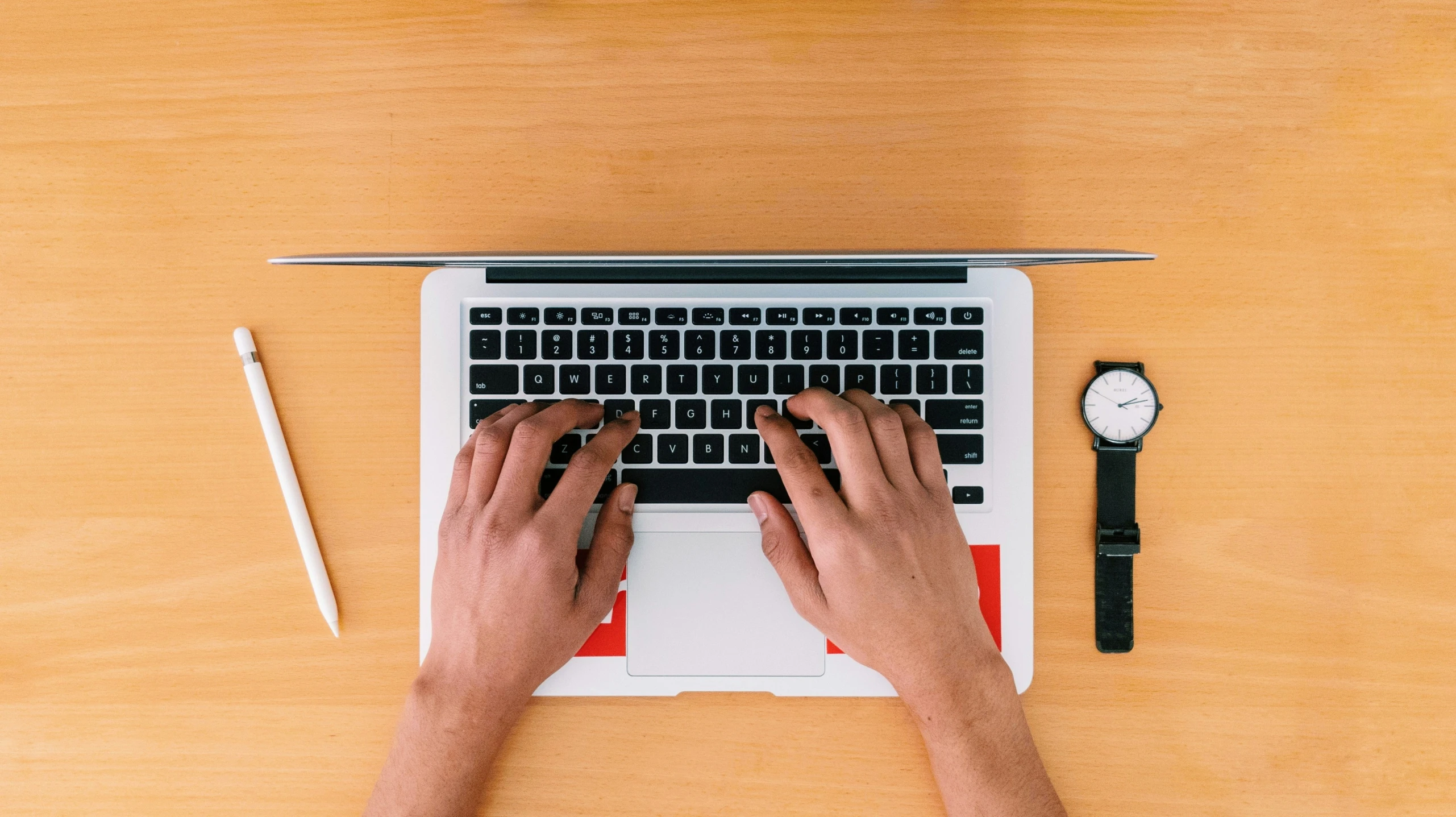 the person is working on their laptop while holding their hands on top of it