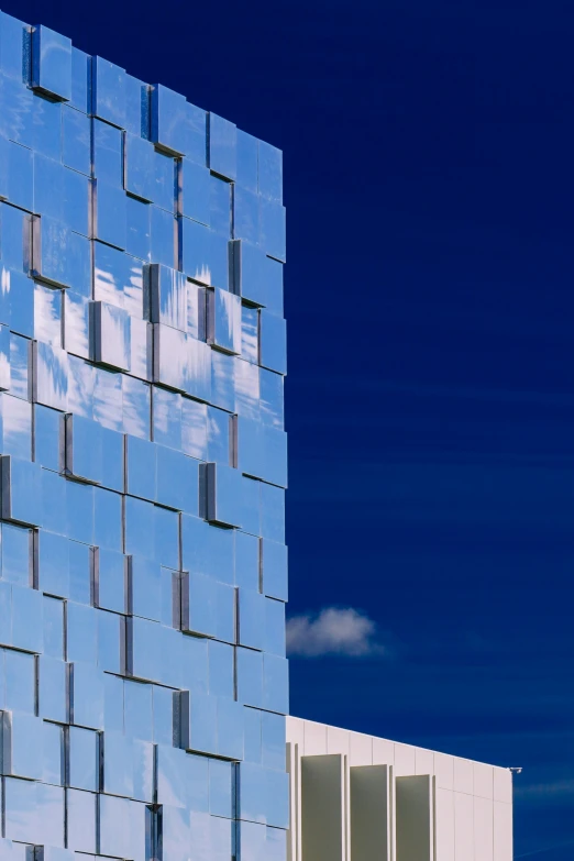 an architectural glass building with windows and sky in background