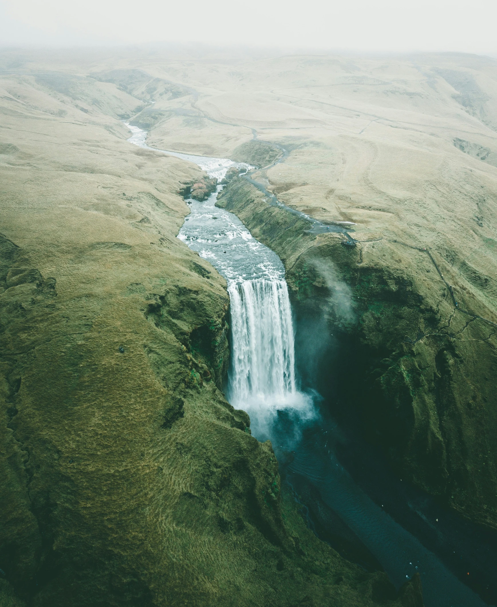 a large body of water surrounded by lush green hills