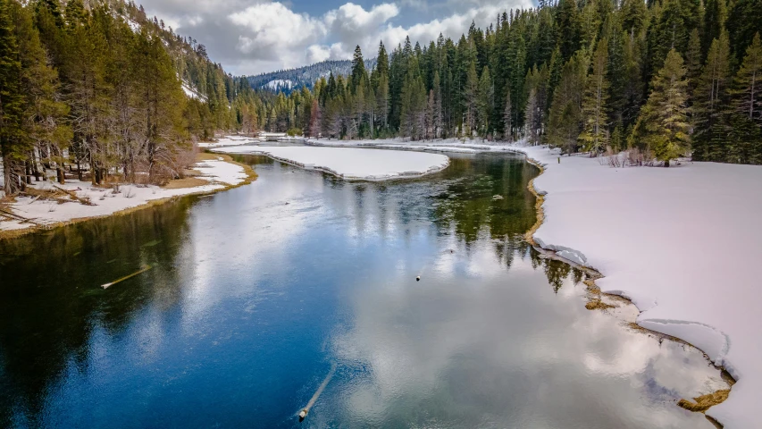 an aerial s of the snow covered river in the woods