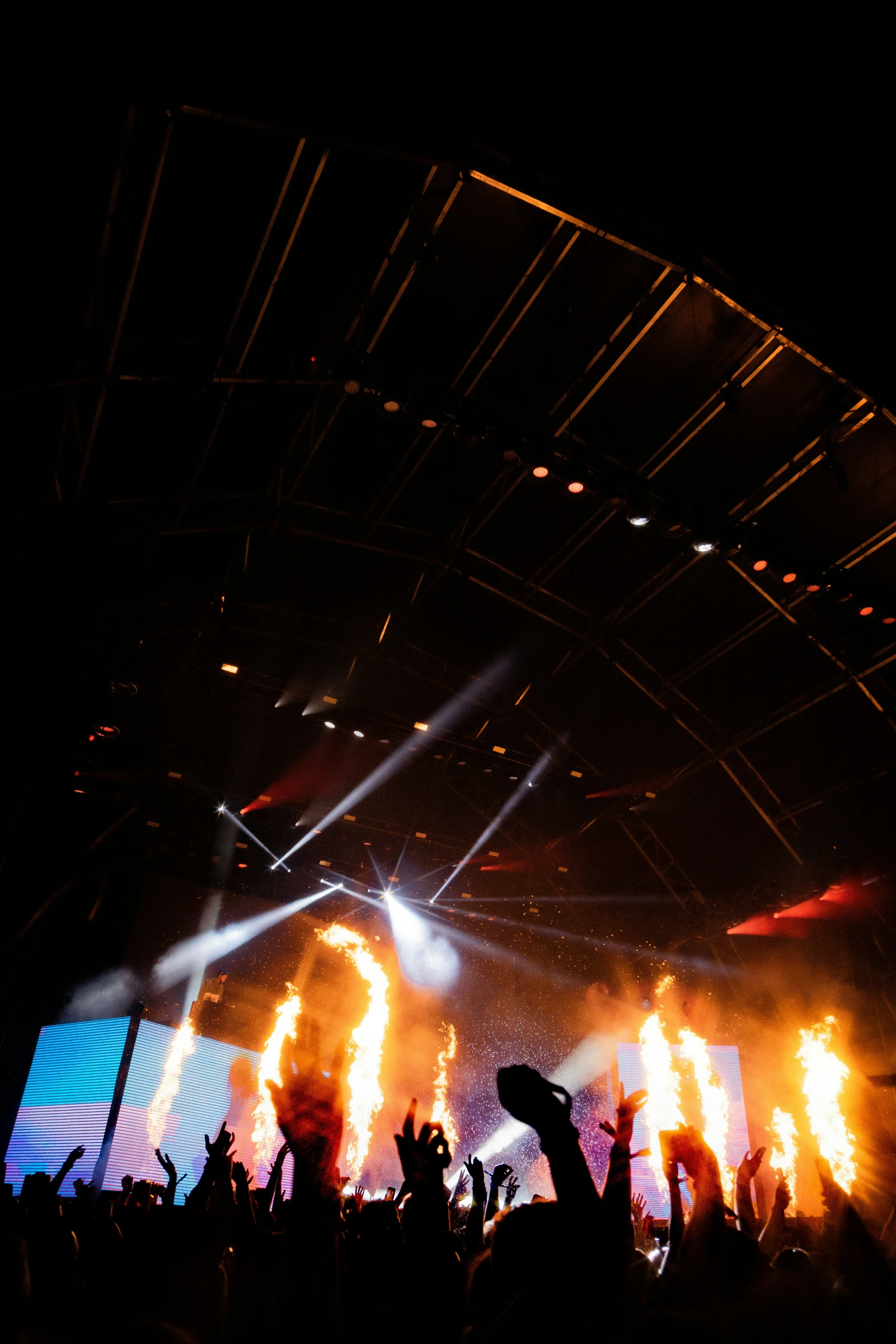 a group of people standing next to a stage on fire