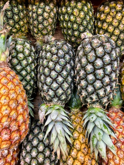 a pile of pineapples are piled high up