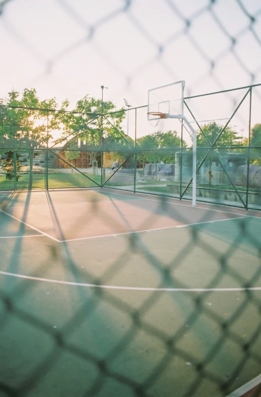 an outdoor basketball court in the evening