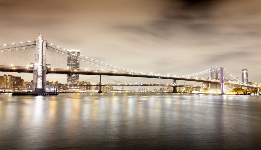 a long bridge crosses over the water in the city