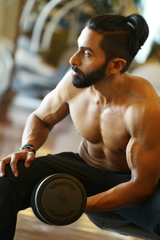 a man with a beard sitting on the ground next to a machine