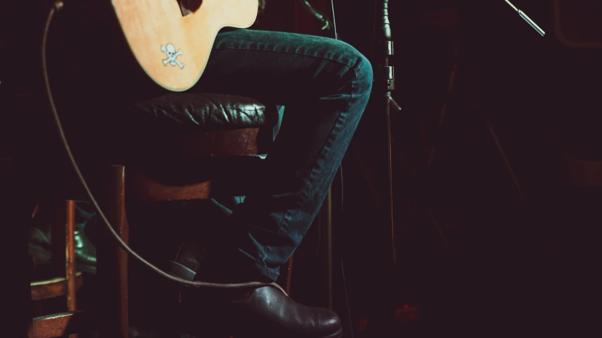 a close up of a person holding an acoustic guitar