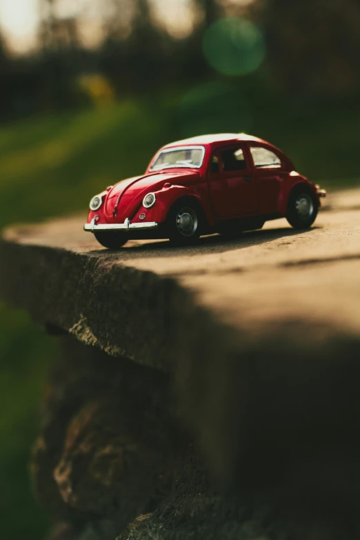 small toy car parked on concrete block with blurry background