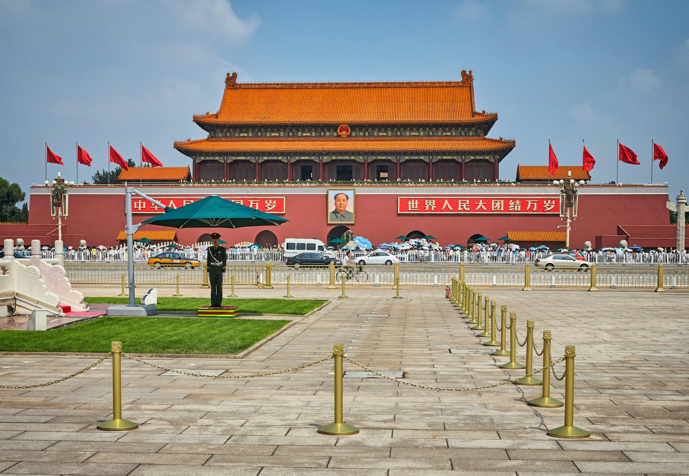 the main building of an ancient city with a golden roof and a few people walking around