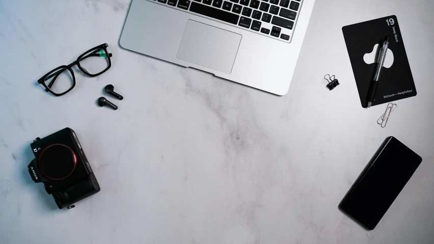 a laptop computer sits on a marble countertop