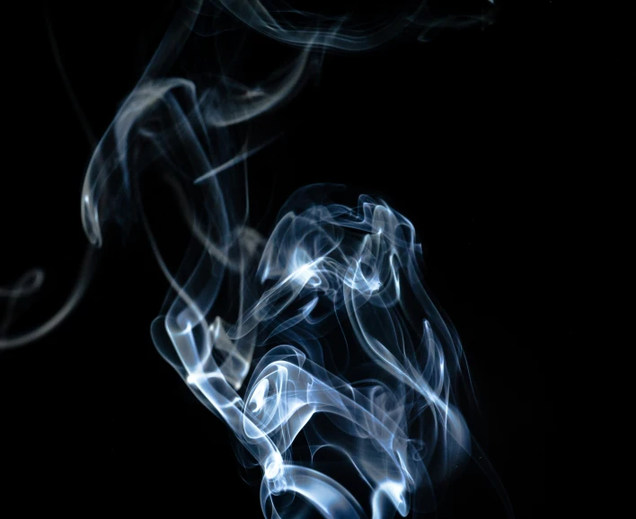 smoke swirls in the dark on a black background