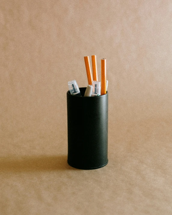 some sort of black cup filled with cigarettes