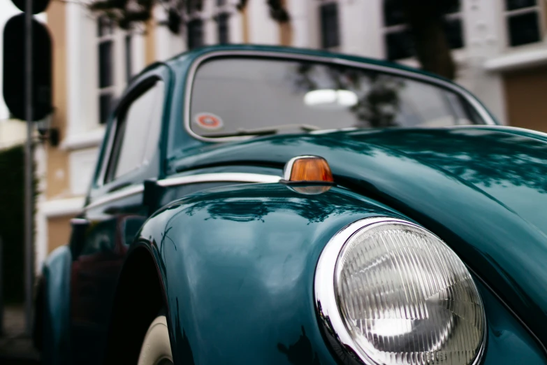 the front end of an old green car is seen in close up