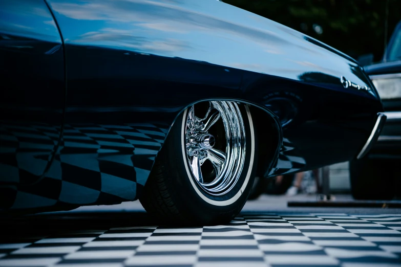 the front tire of a classic car parked in a parking lot