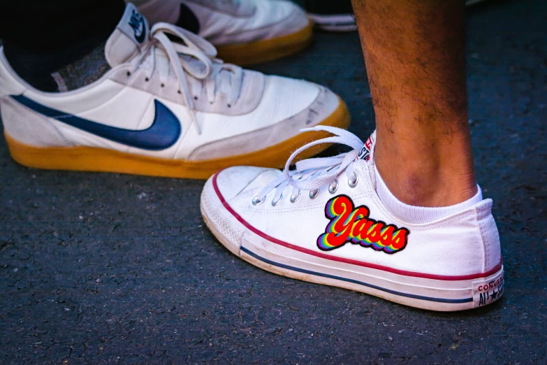 a close - up of the shoes worn by a person wearing white sneakers