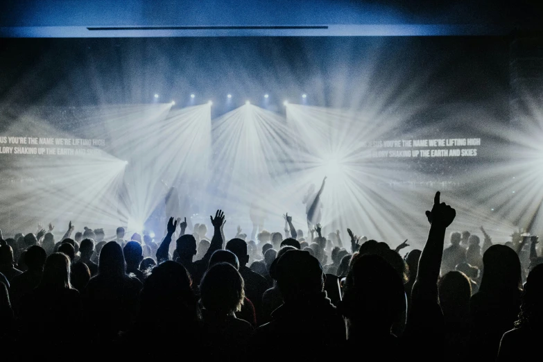 the back lit stage of an event with lights and a crowd