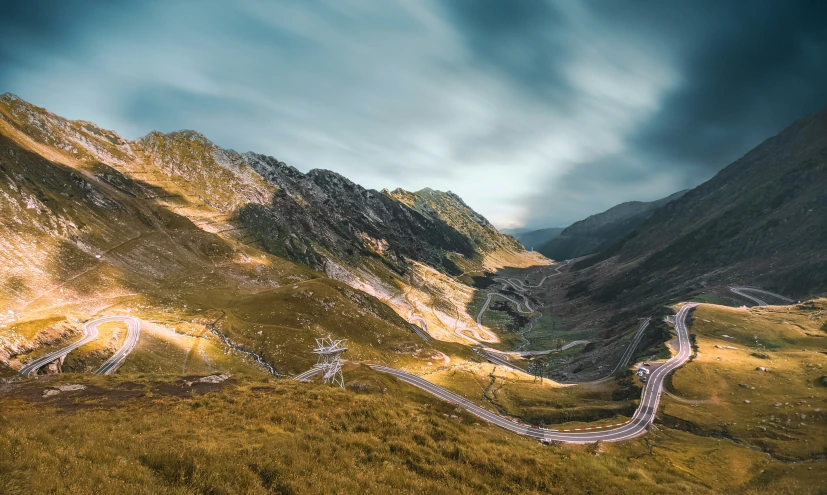 a scenic view of a hilly mountain with a road going in it