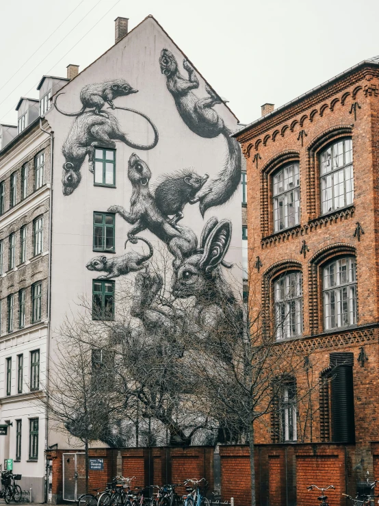 a painted mural of people on building next to bicycles
