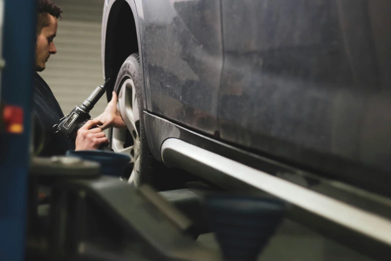 a man using an air hose to clean the tire of his truck