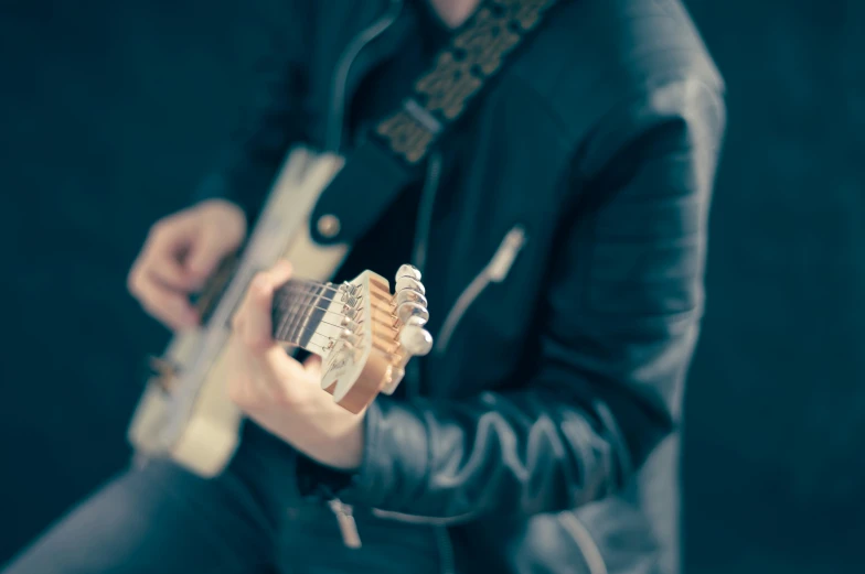 a young person with an electric guitar poses for a portrait