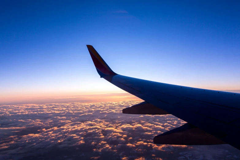 the wing of an airplane flying over clouds