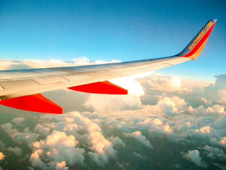 the wing of an airplane flying over the clouds