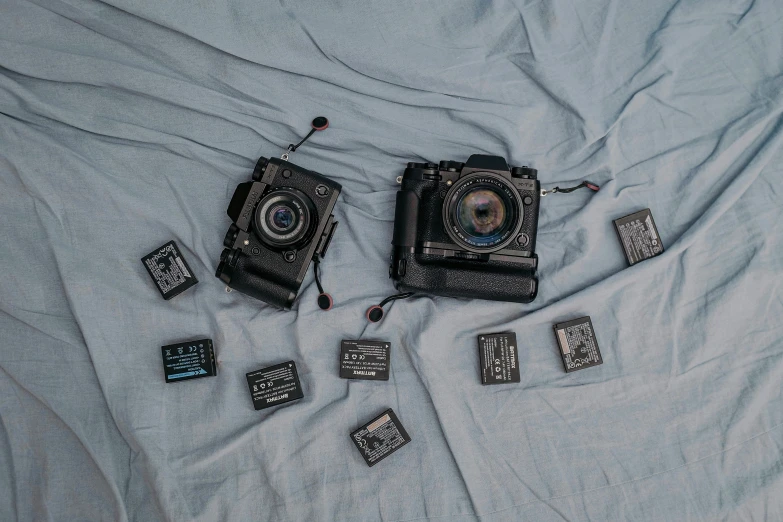 three antique camera and square magnets lie on a bed