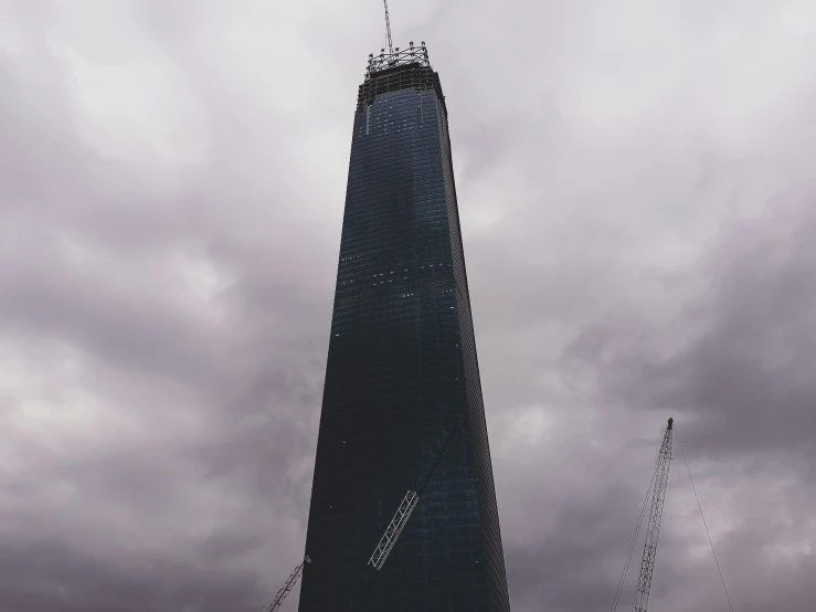 two people with parasols standing at the base of a tall building